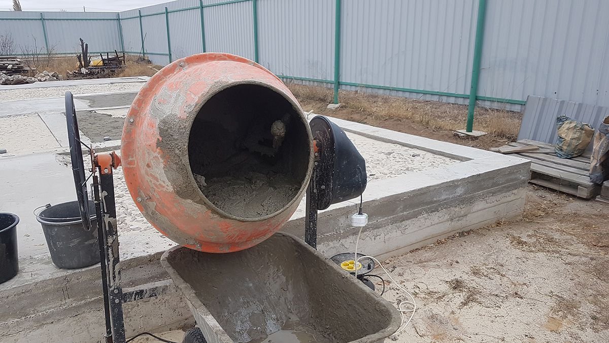 Бетономешалка с бетоном. Замешивание бетона в бетономешалке. Бетона мешалка на стройке. Замес бетона в бетономешалке. Бетономешалка с цементом.