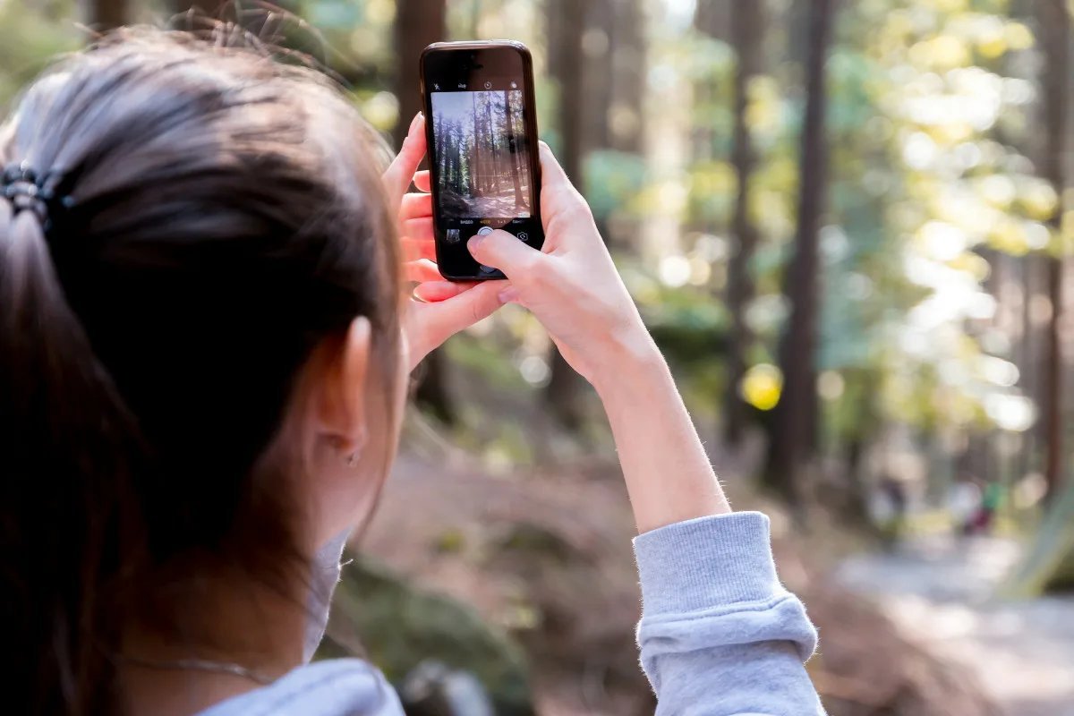 С помощью смартфона. Человек снимает на телефон. Фотографирует на телефон. Человек фоткает на телефон. Человек фотографирует на смартфон.