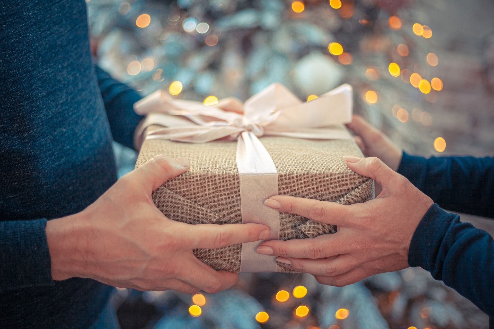 Преподносит приятные сюрпризы. Подарок в руках. Дарим подарки. Подорки в руках. Человек дарит подарок другому.