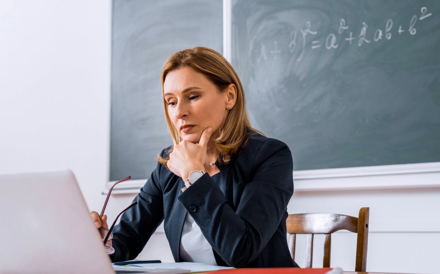 Размышления педагога. Учитель за столом. Женщина педагог. Преподаватель картинка. Учитель сидит.