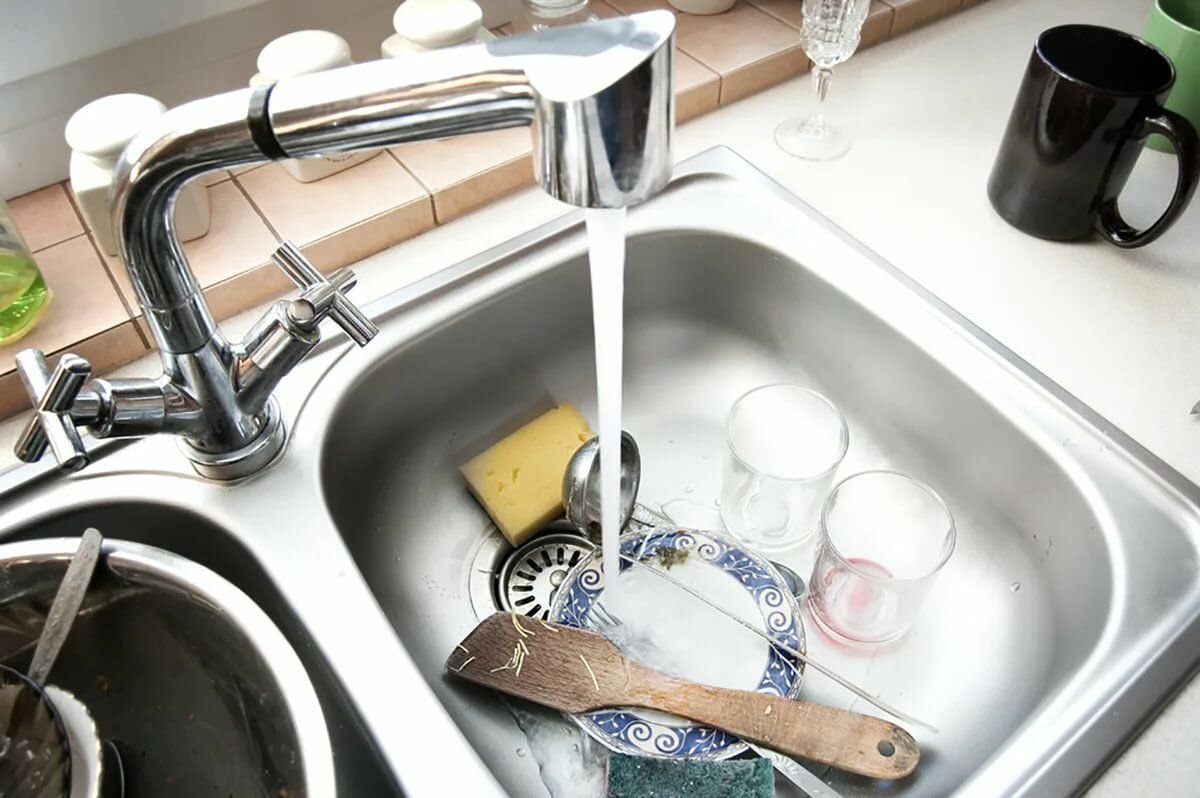 В раковине течет вода. Раковина кран вода. Смеситель на мойку грязной посуды кухни. Мытье посуды под краном. Кран с водой.