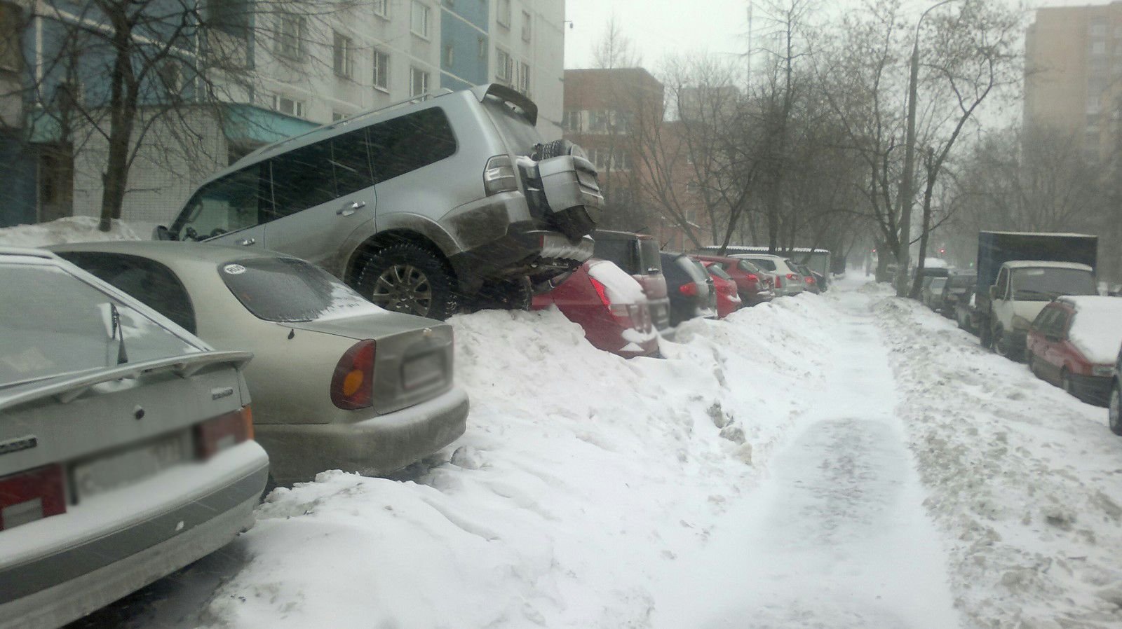 Не чищено во дворе. Парковка в сугробе. Снегопад и парковка. Припарковался на сугробе. Машина в сугробе во дворе.