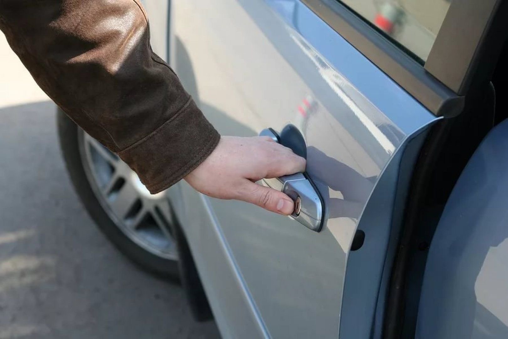 Открывает дверь автомобиля