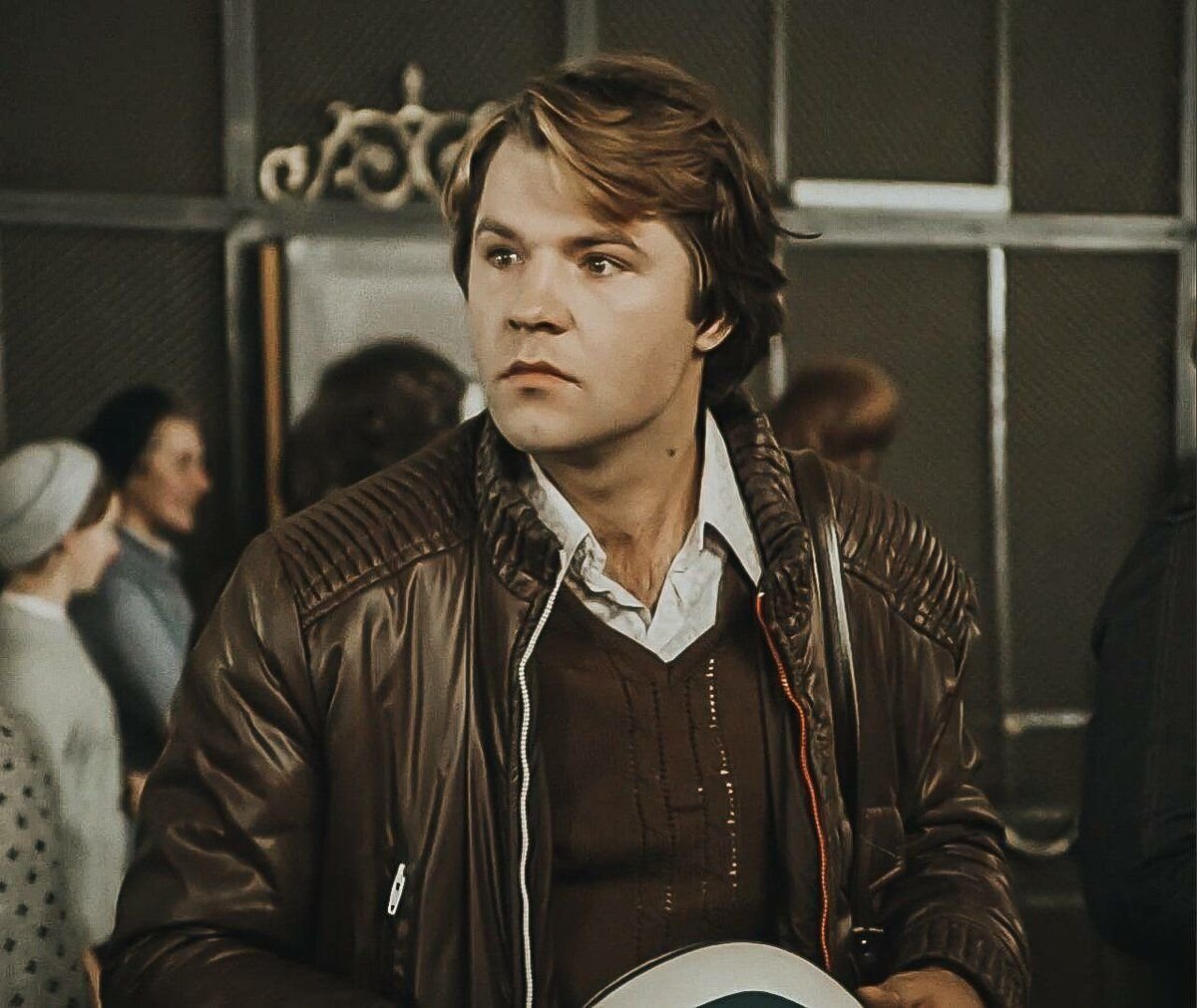 Александр Фатюшин в холле статистического учреждения. В руках у него мотоциклетный шлем. Сцены, где они с Верочкой гоняют по Москве на мотоцикле, полностью вырезаны. Кадр из фильма «Служебный роман», 1977