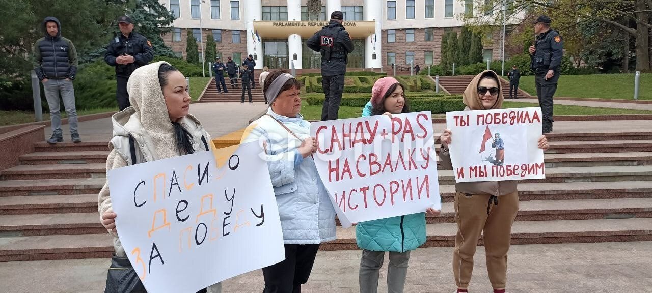 Бабушка с флагом живы. Человек с плакатом. Парламент Молдовы Георгиевская лента. Георгиевская лента в Молдове. Бабки с плакатом.