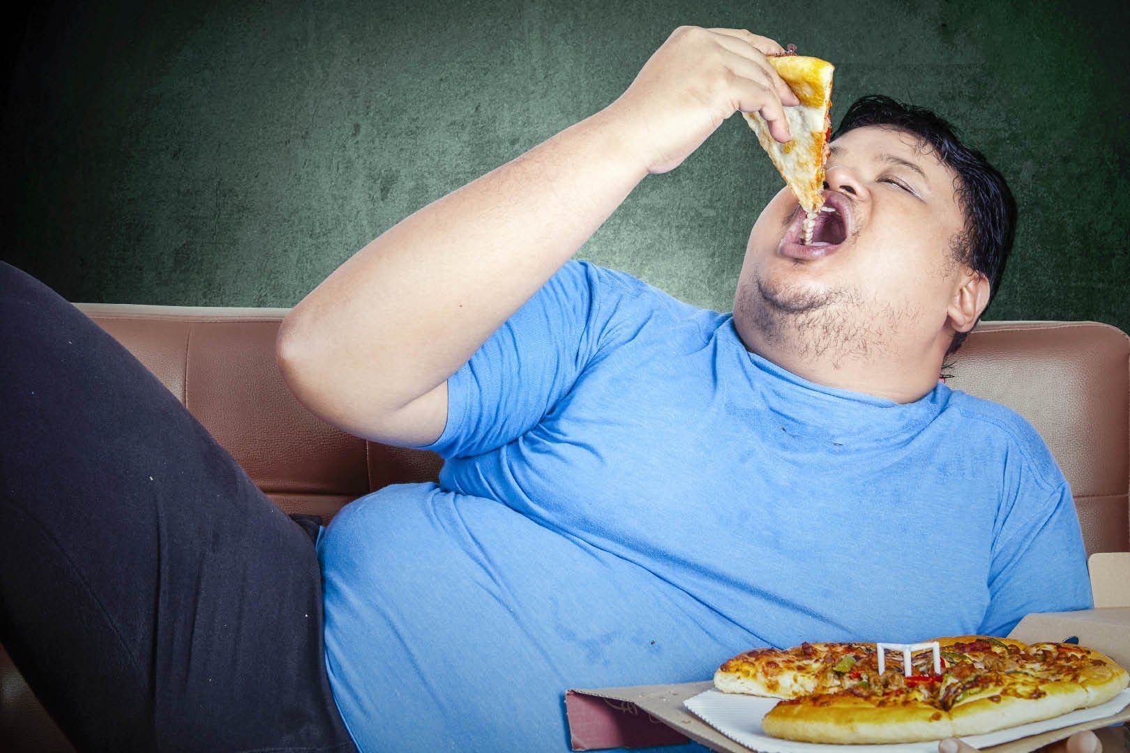Толстый человек ест человека