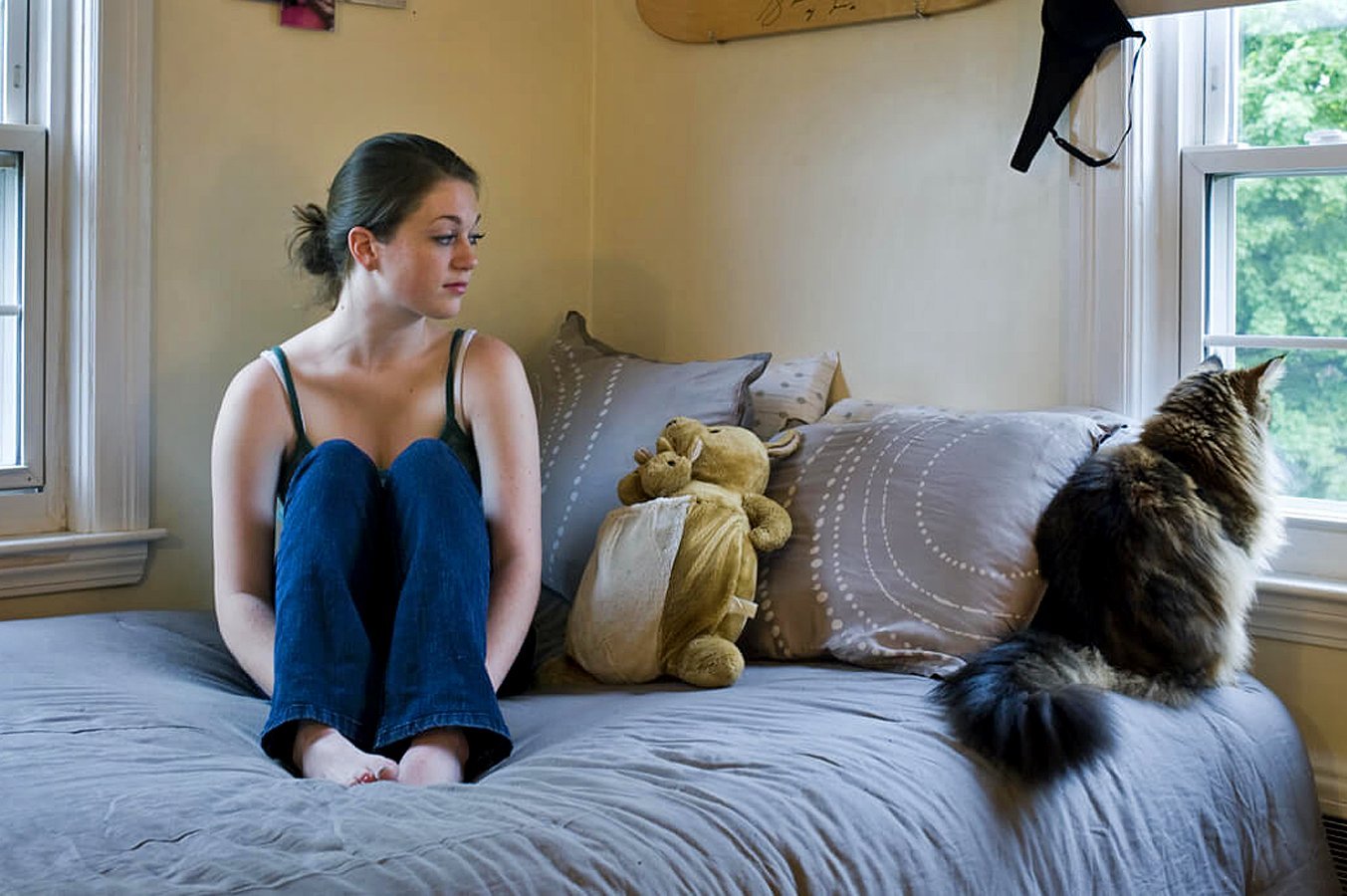 Девушка сидит на берегу моря. Одиночество в толпе. Одинокая женщина. Грустная женщина. Много одиноких.