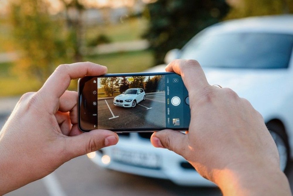 Телефон машина. Фотографирование автомобиля. Фотографирование автомоделей. Фотографирует машину. Человек фотографирует автомобиль.