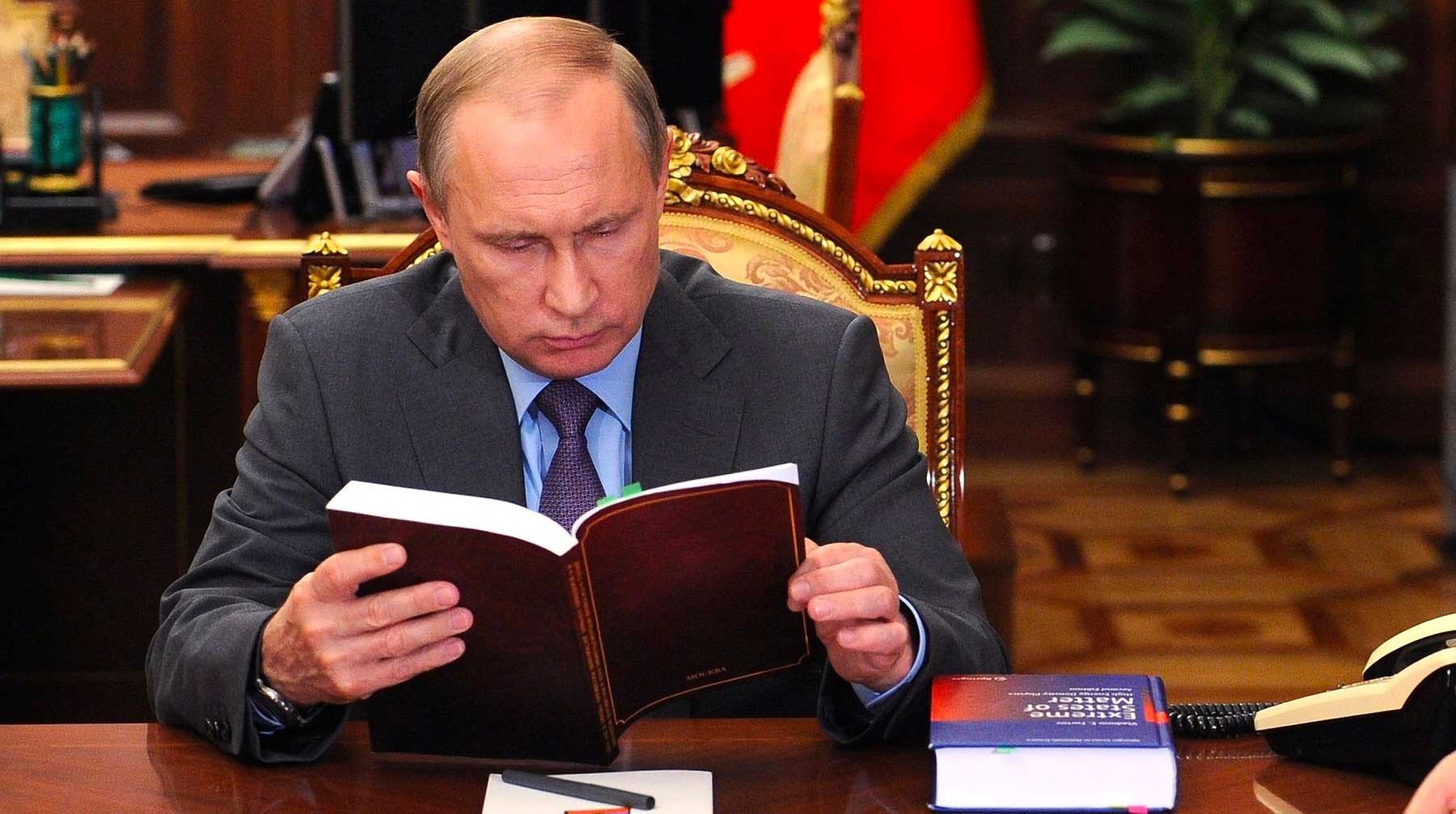 Книга путиной. Путин. Путин читает книгу. Путин за столом в кабинете. Владимир Путин за столом.