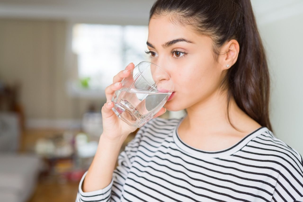 Пить стакан воды натощак. Девушка со стаканом воды. Девушка пьет из стакана. Питье воды. Девушка пьет воду из стакана.