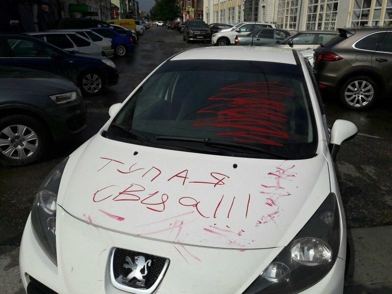 Парень нацарапал на борту чужого автомобиля какой то рисунок