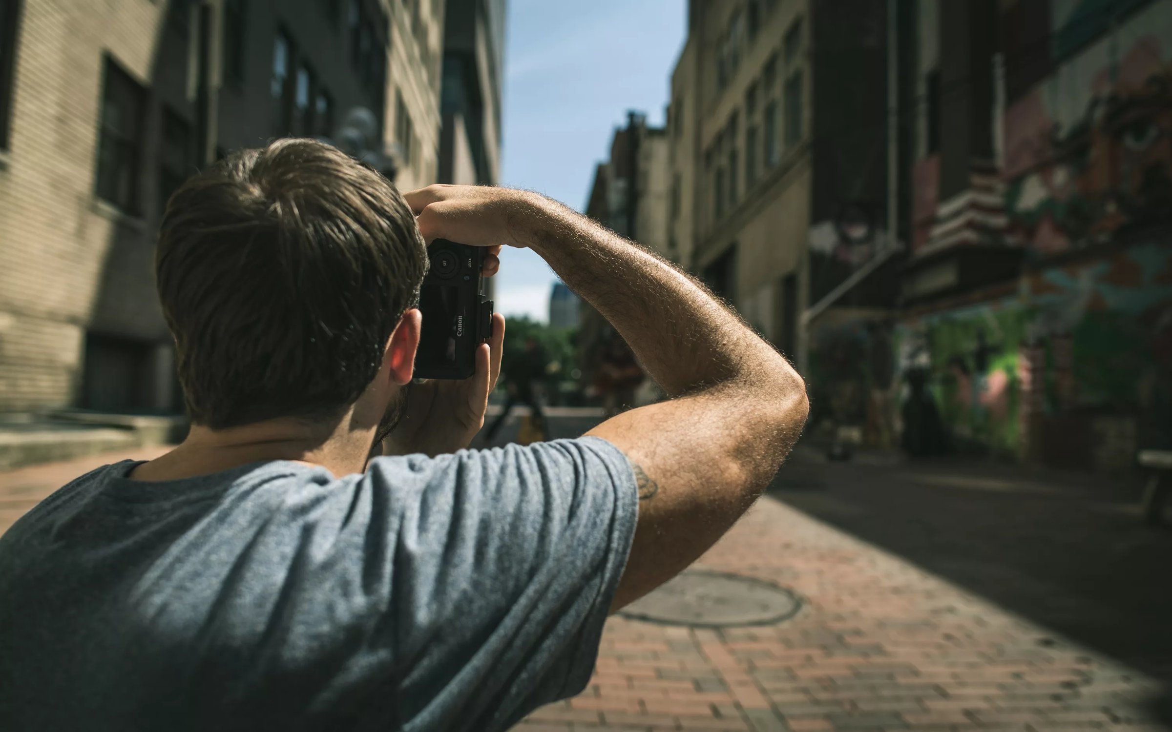 Смотря где. Чел фоткает на улице. Человек фоткает улицу. Фотограф на улице. Человек фотографирует на улице.