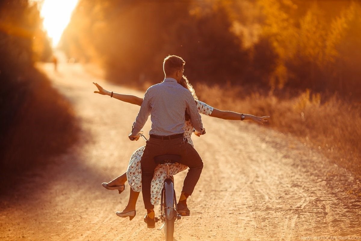 Парень и девушка спина к спине. Парин и девушка држутся за руку. Двое на весу. Влюбленные на берегу моря. Мужчина и женщина на море.