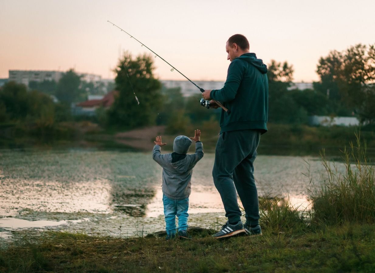 Сын ловит рыбу. Рыбалка с папой. Отец и сын на рыбалке. Дети на рыбалке. Папа с малышом на рыбалке.