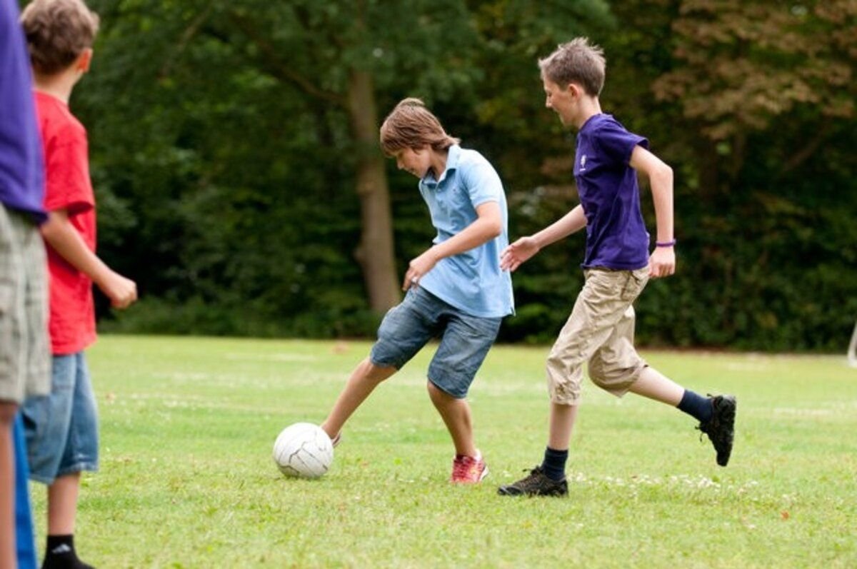 He play football with his friends. Футбол дети. Игры на улице для подростков. Игра футбол. Играющие дети.