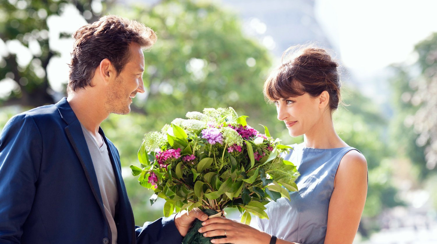 Человек ухаживающий за женщиной. Парень дарит девушке цветы. Мужчина дарит цветы женщине. Мужчина дарит букет цветов. Парень даёт девушке цветы.