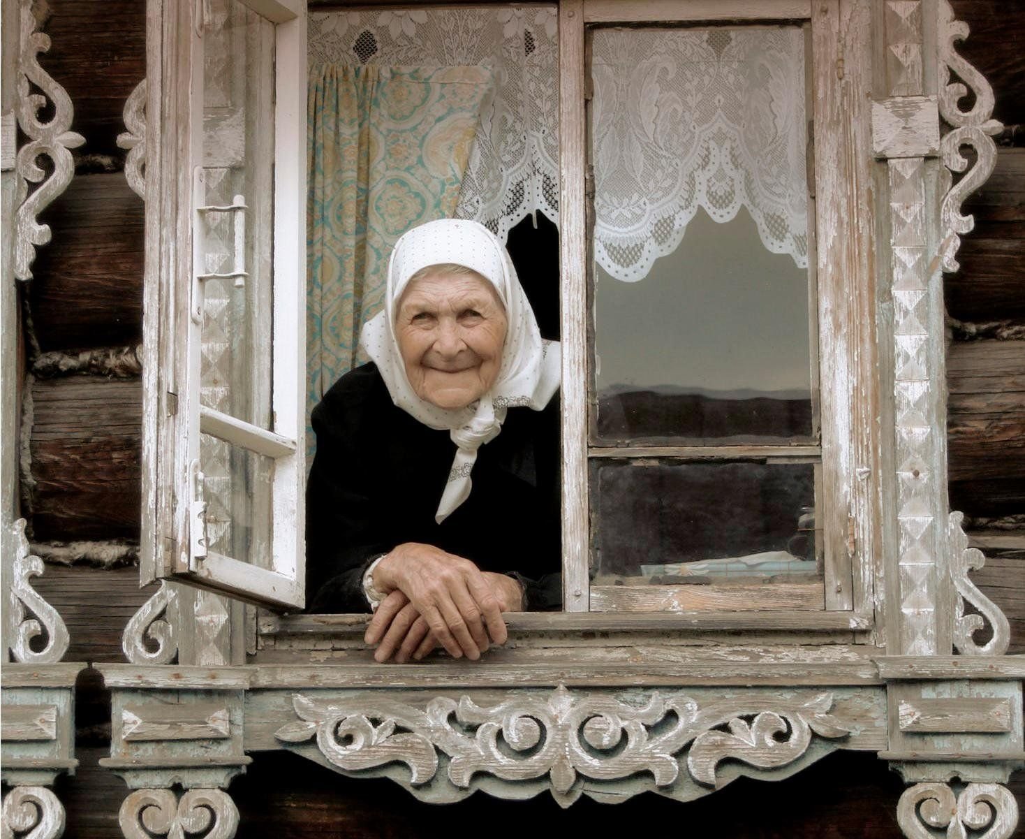 Видеть покойную бабушку живой. Бабушка у окна. Бабушка в окошке. Старушка у окна. Старушка у окна в деревне.