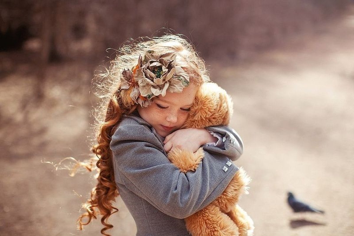 Ребенок обнимает игрушку. Девочка обнимает мишку. Доброта и нежность. Девочка обнимает игрушку. Заботиться о чужом ребенке