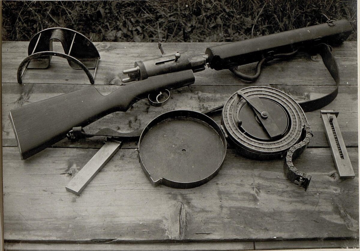 Пистолет-пулемёт Maschinengewehr des Standschützen Hellriegel M1915. Рядом лежит открытый барабанный магазин, люлька для его поддержки и два коробчатых магазина. Фото из открытых источников.