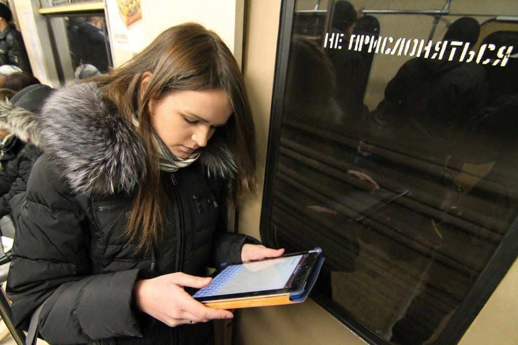 Подросток в московском метро. Люди со смартфонами в метро. Человек читает электронную книгу в метро. Читает телефон в метро. Вай фай в Московском метро.
