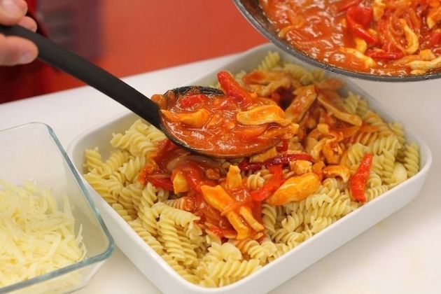 Выкладываем макароны в ёмкость для духовки и заливаем приготовленным соусом из лука и овощей